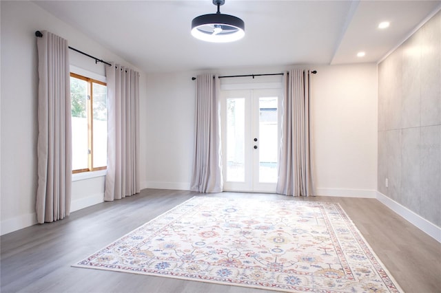 empty room with light wood-style floors, french doors, and baseboards