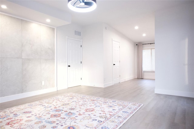 unfurnished room with recessed lighting, visible vents, light wood-style flooring, and baseboards