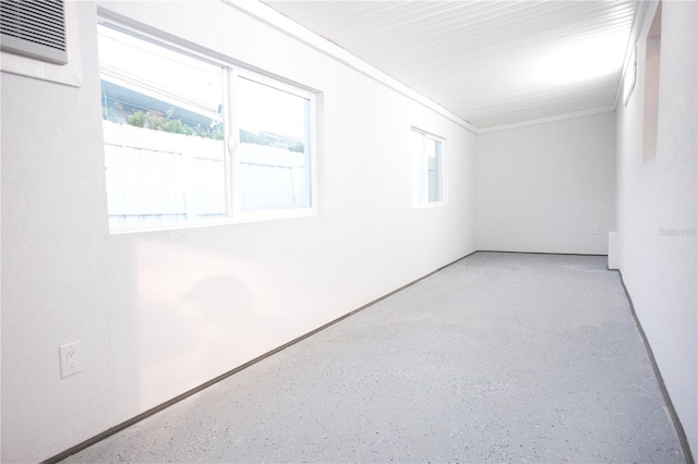 spare room featuring speckled floor and a healthy amount of sunlight