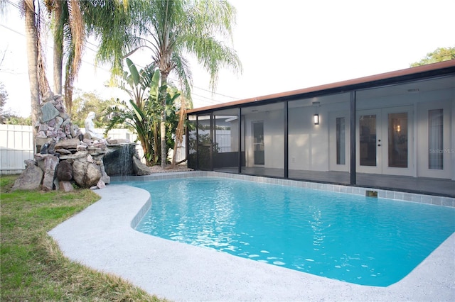 view of pool with french doors and a sunroom