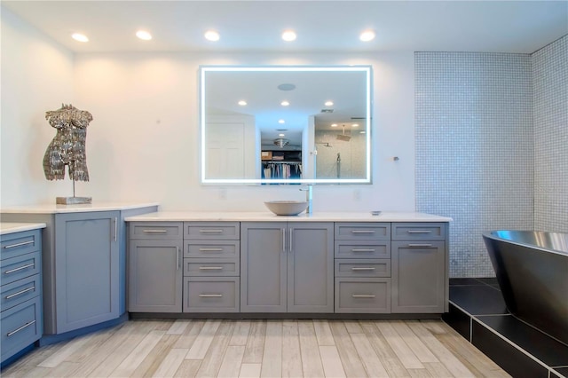 bathroom with vanity, separate shower and tub, and hardwood / wood-style floors