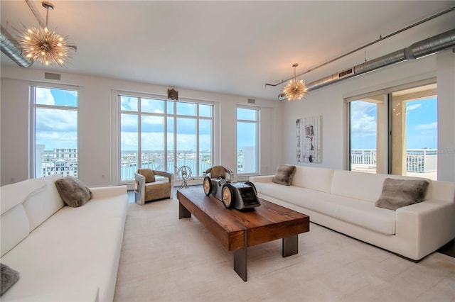 living room featuring an inviting chandelier and a water view