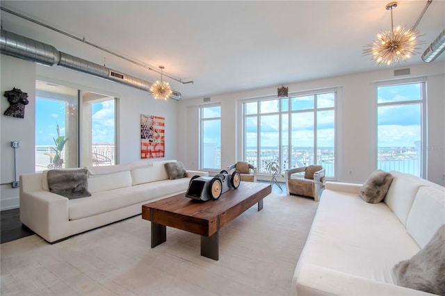 living room with a notable chandelier and a water view