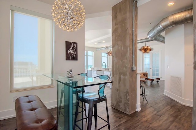 dining area with dark wood-type flooring and a chandelier