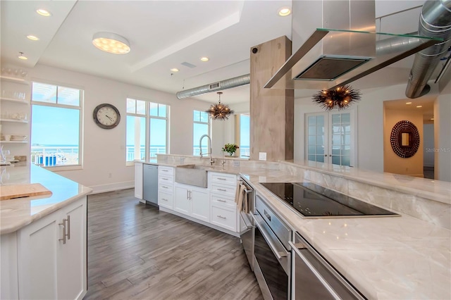 kitchen featuring white cabinetry, sink, light stone counters, stainless steel appliances, and light wood-type flooring