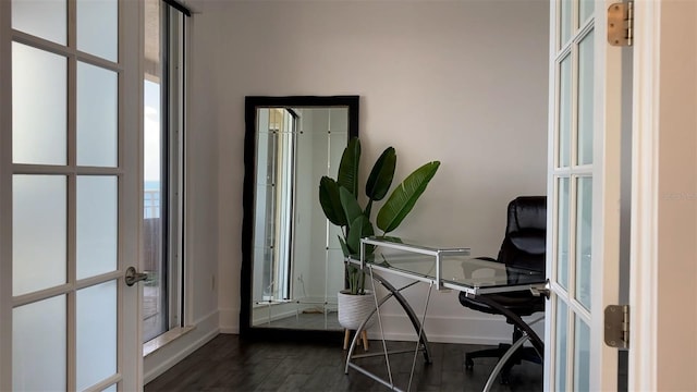 home office with dark hardwood / wood-style floors and french doors