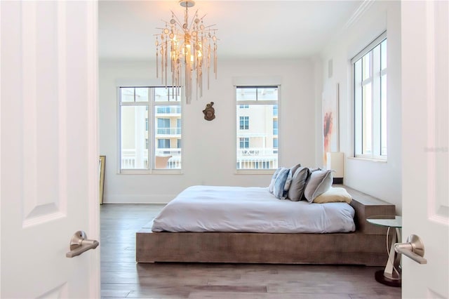 bedroom with wood-type flooring and an inviting chandelier