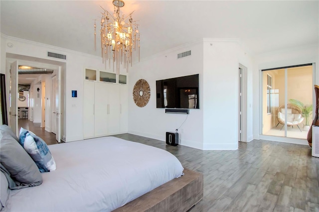 bedroom with crown molding, hardwood / wood-style floors, and a chandelier