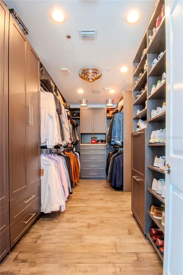 spacious closet with light hardwood / wood-style floors