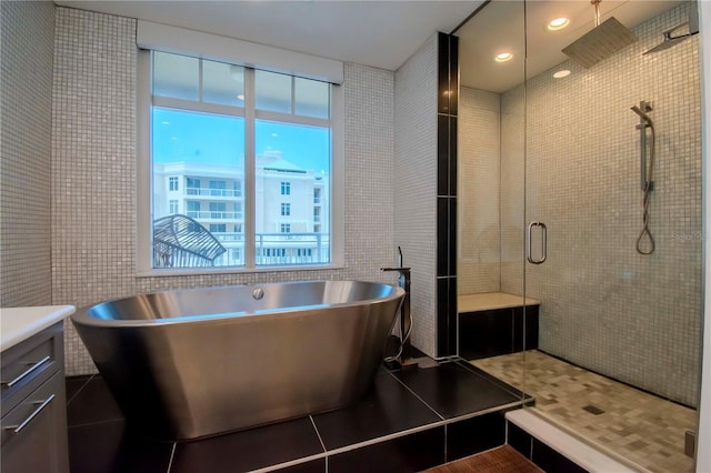 bathroom featuring tile patterned floors, shower with separate bathtub, tile walls, and vanity