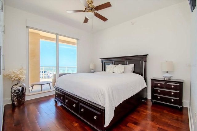 bedroom with a water view, ceiling fan, dark hardwood / wood-style flooring, and access to exterior