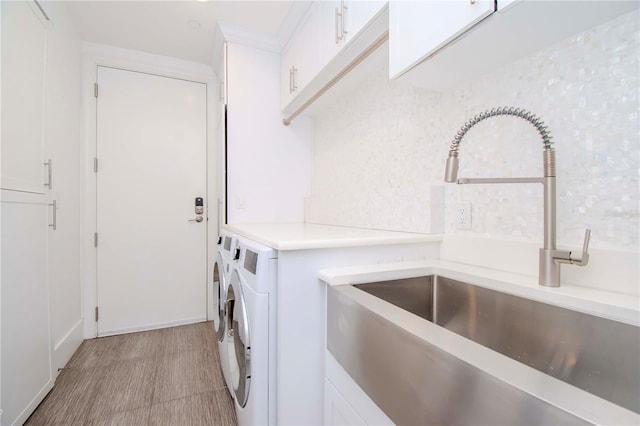 laundry room with cabinets, independent washer and dryer, and sink