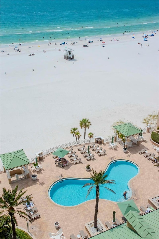 view of swimming pool featuring a view of the beach, a gazebo, and a water view