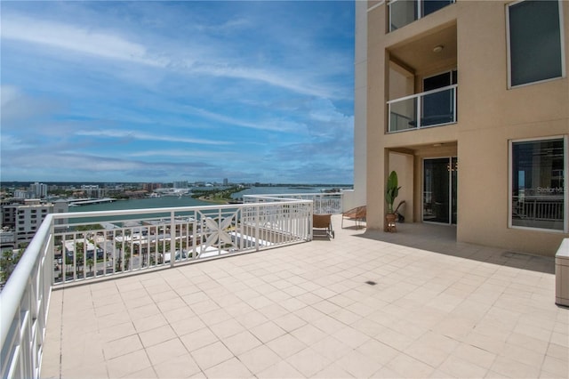 view of patio / terrace with a balcony and a water view