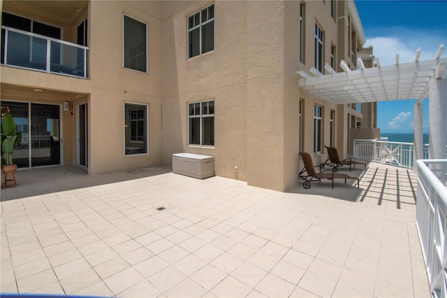 view of patio / terrace with a water view and a pergola