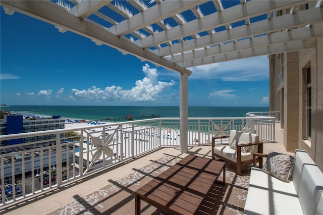 balcony featuring an outdoor living space, a beach view, and a water view