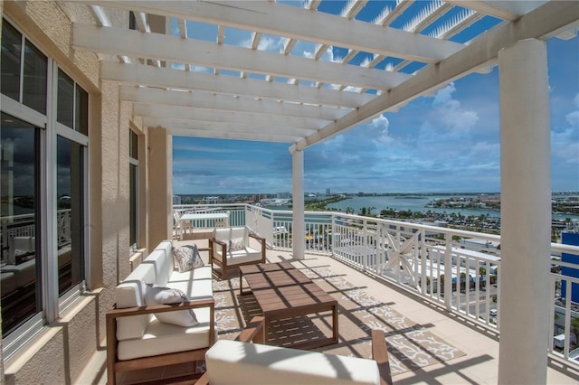 balcony with an outdoor living space, a pergola, and a water view