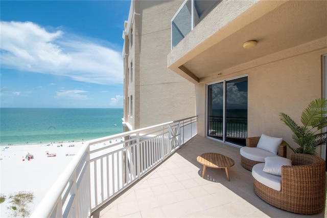 balcony featuring a water view and a beach view