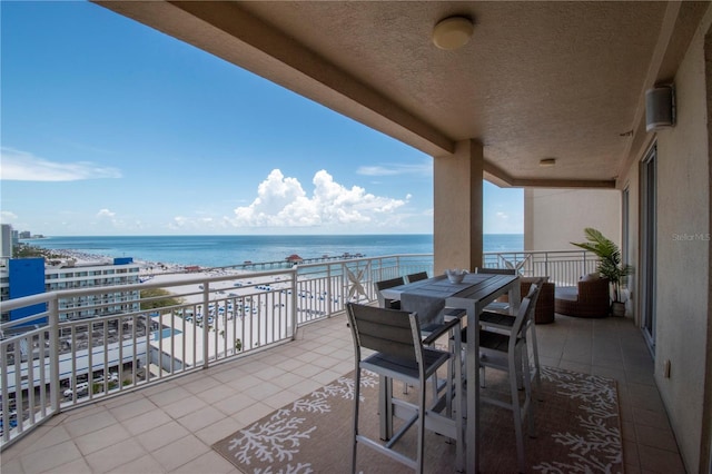 balcony featuring a water view and a beach view