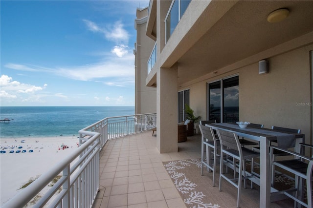 balcony with a water view and a view of the beach