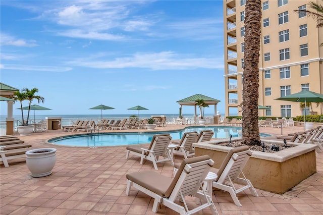 view of pool featuring a water view and a patio area