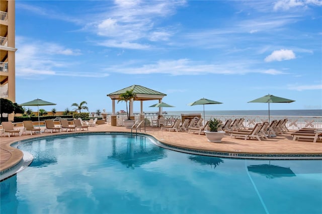 view of swimming pool with a gazebo, a water view, and a patio area