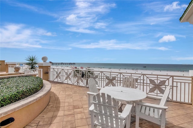 view of patio featuring a water view and a beach view