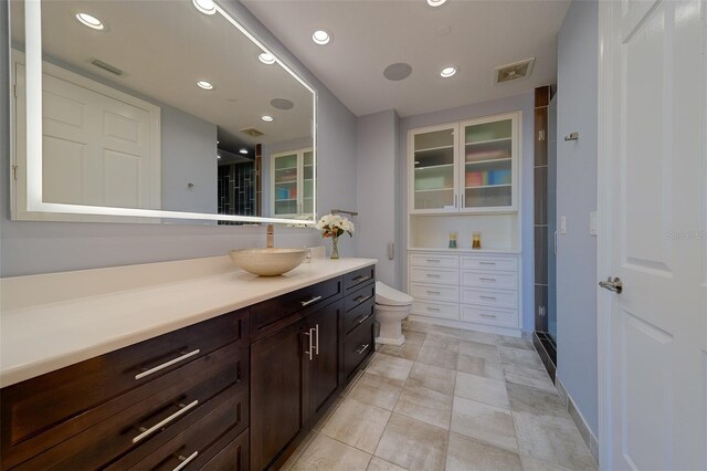 bathroom with visible vents, toilet, vanity, and a shower stall