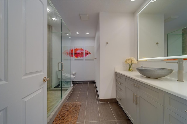 bathroom with a stall shower, toilet, tile patterned floors, vanity, and recessed lighting