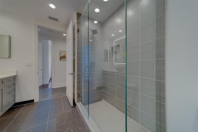 full bath featuring visible vents, a shower stall, vanity, tile patterned flooring, and baseboards