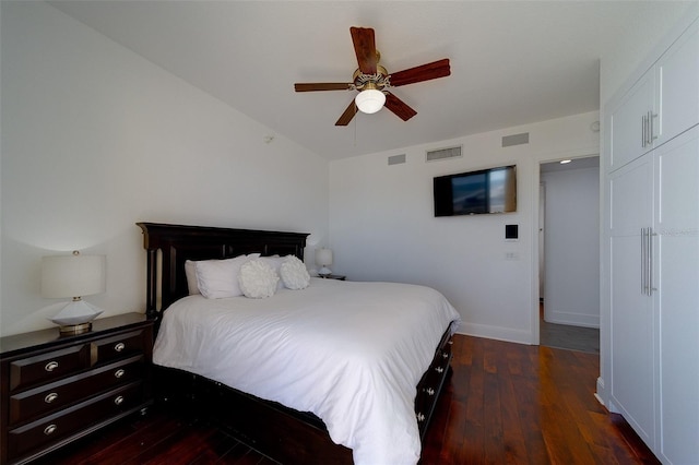 bedroom with ceiling fan, visible vents, baseboards, vaulted ceiling, and wood-type flooring