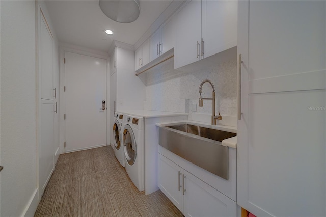 clothes washing area featuring cabinet space, recessed lighting, a sink, and washing machine and clothes dryer