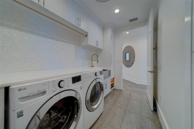 laundry room featuring visible vents, cabinet space, a sink, washer and dryer, and baseboards