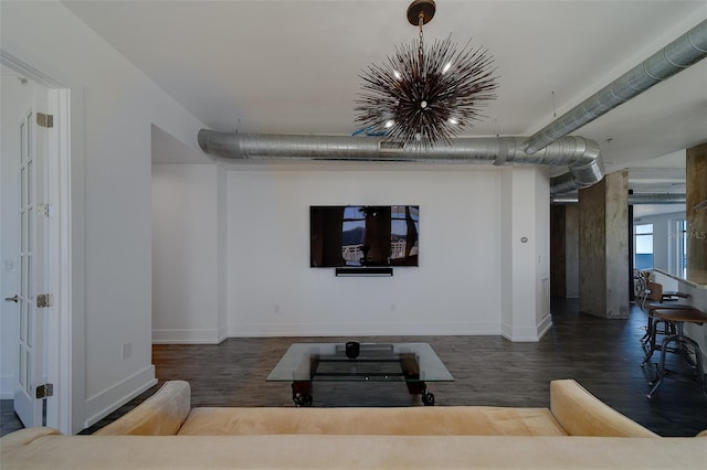 living room with a notable chandelier, baseboards, and wood finished floors