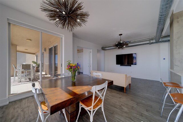 dining space with a chandelier, baseboards, and wood finished floors