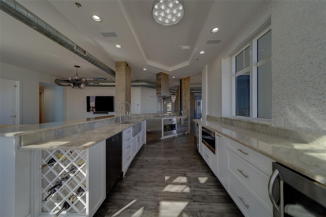 kitchen featuring extractor fan, beverage cooler, stainless steel oven, dishwasher, and an inviting chandelier