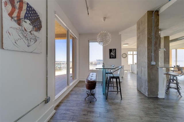 dining room featuring a notable chandelier, baseboards, and dark wood-type flooring