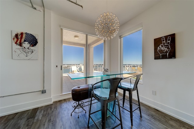 dining room with a healthy amount of sunlight, baseboards, and wood finished floors