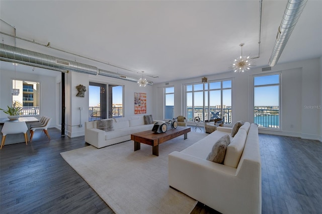 living room with plenty of natural light, wood finished floors, and an inviting chandelier