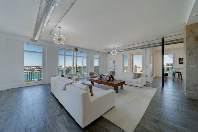 living room with baseboards, a chandelier, and dark wood-style flooring