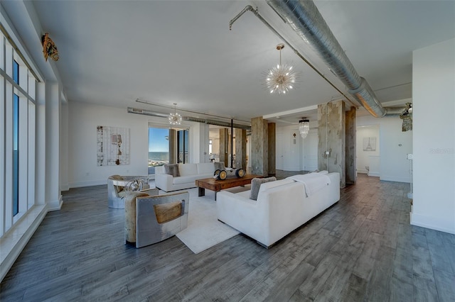 living room with a chandelier, wood finished floors, and baseboards