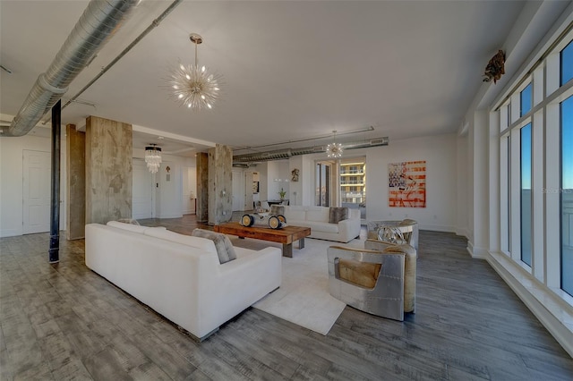 living area featuring a chandelier, wood finished floors, and baseboards