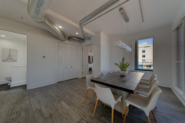 dining space featuring dark wood-type flooring and baseboards