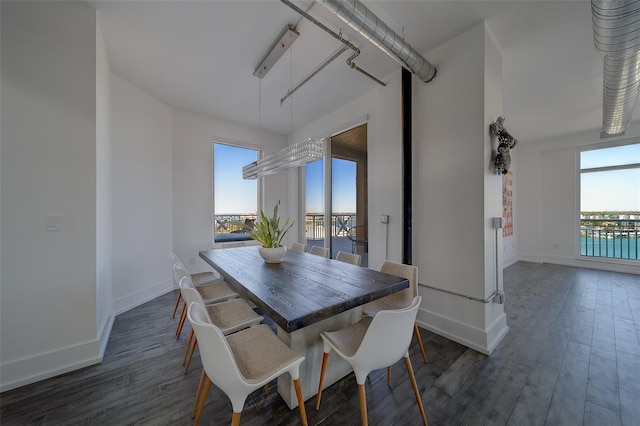 dining space with baseboards and dark wood finished floors