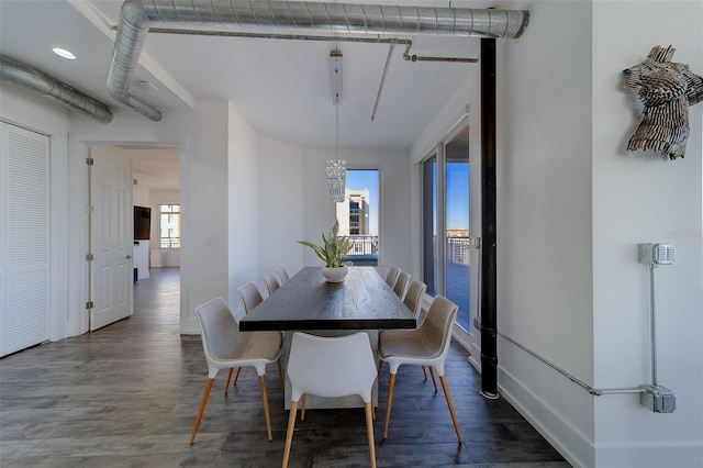 dining area featuring baseboards, a chandelier, and wood finished floors