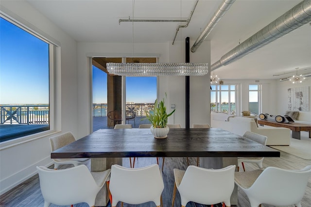 dining room with plenty of natural light, a chandelier, and wood finished floors