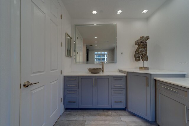 bathroom featuring vanity, wood finish floors, and recessed lighting