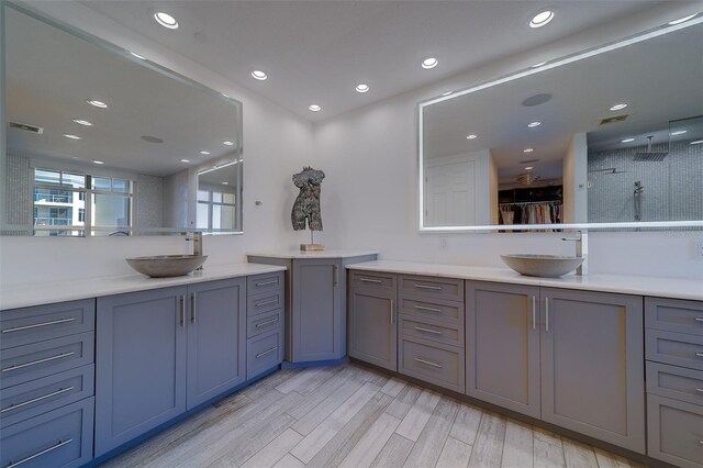 bathroom with two vanities, visible vents, a sink, and wood finished floors