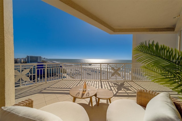 balcony featuring a water view and a view of the beach