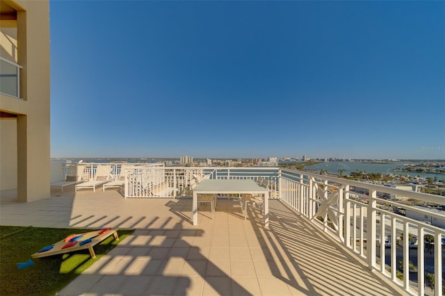 view of patio featuring a water view and a balcony